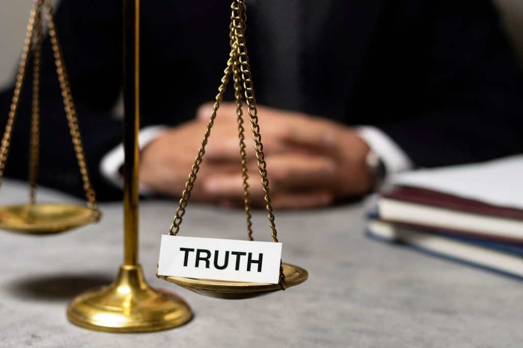 Scales of justice engraved with the word Truth