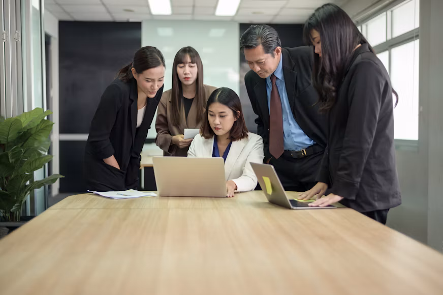 A group of business attorneys in La Cañada Flintridge gathered around a conference table looking at a laptop.