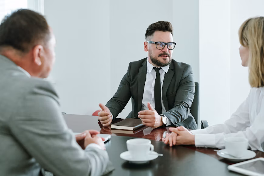 Three business attorneys from Pacific Palisades sit around a conference table during a meeting.