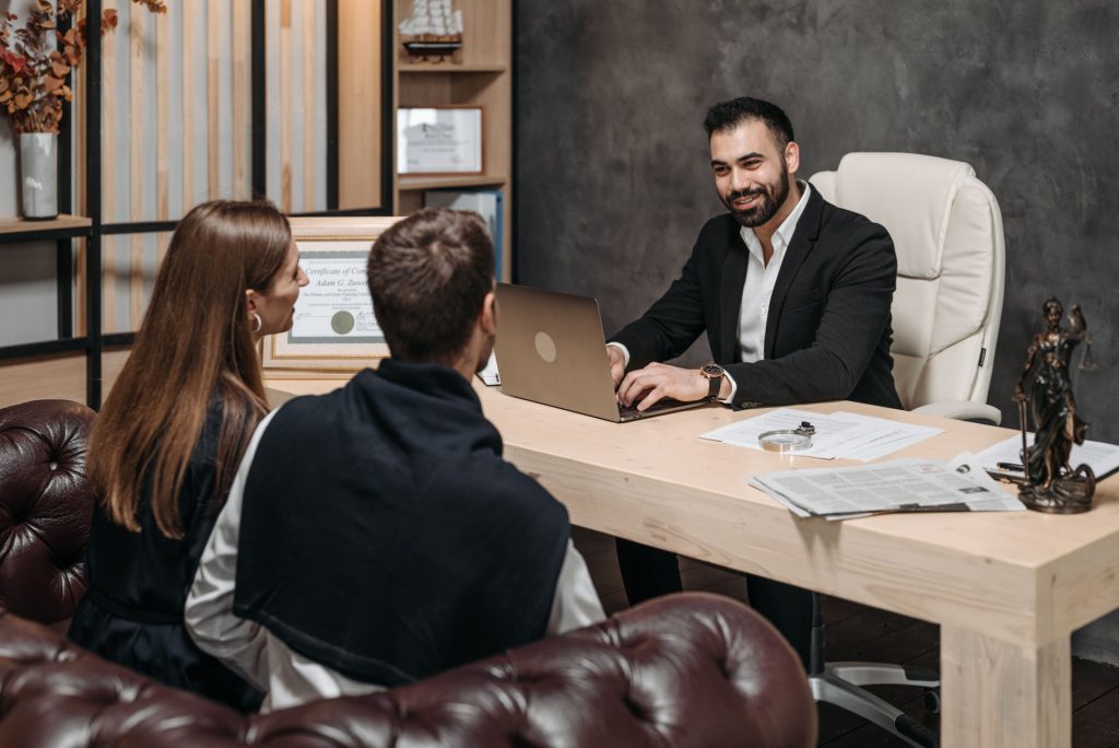 A business lawyer in Playa Vista consults with a couple at an office desk.