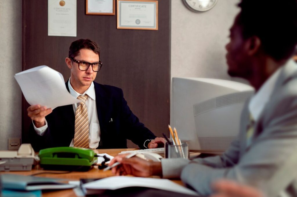Man in glasses reviewing a document with colleagues
