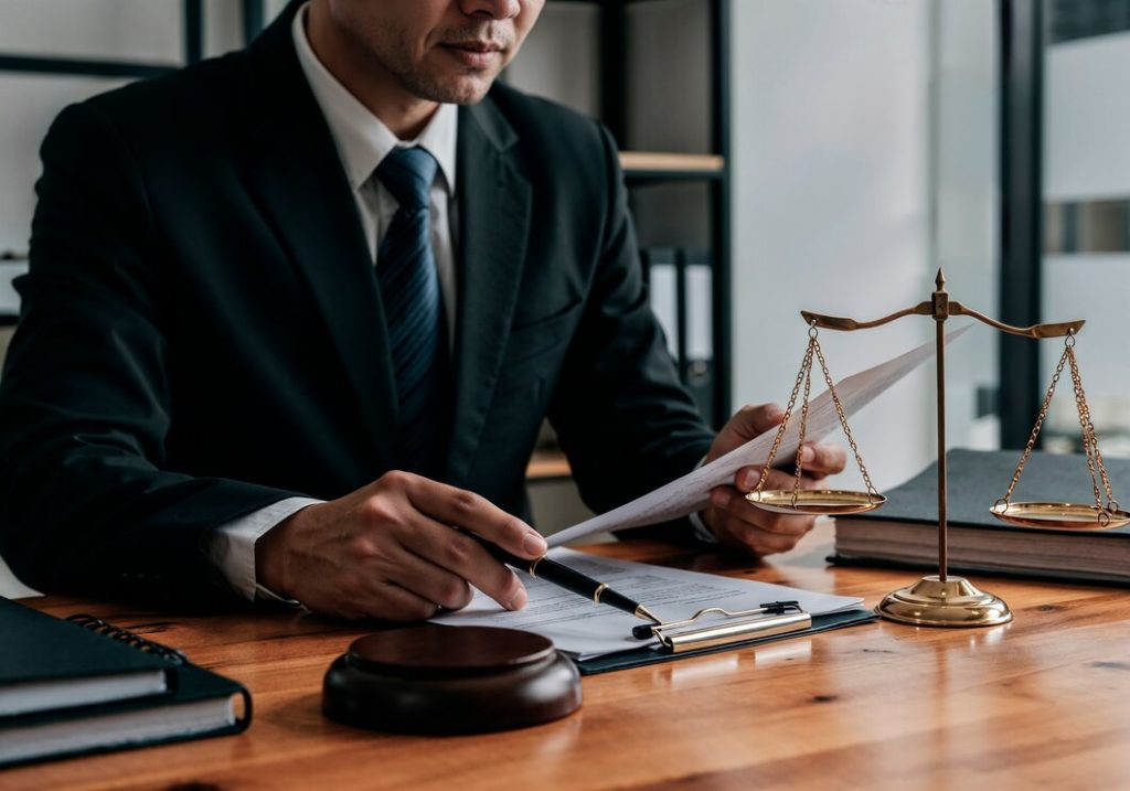 A business lawyer in Valley Village sits at a desk with a document, a gavel, and a gold balance scale.