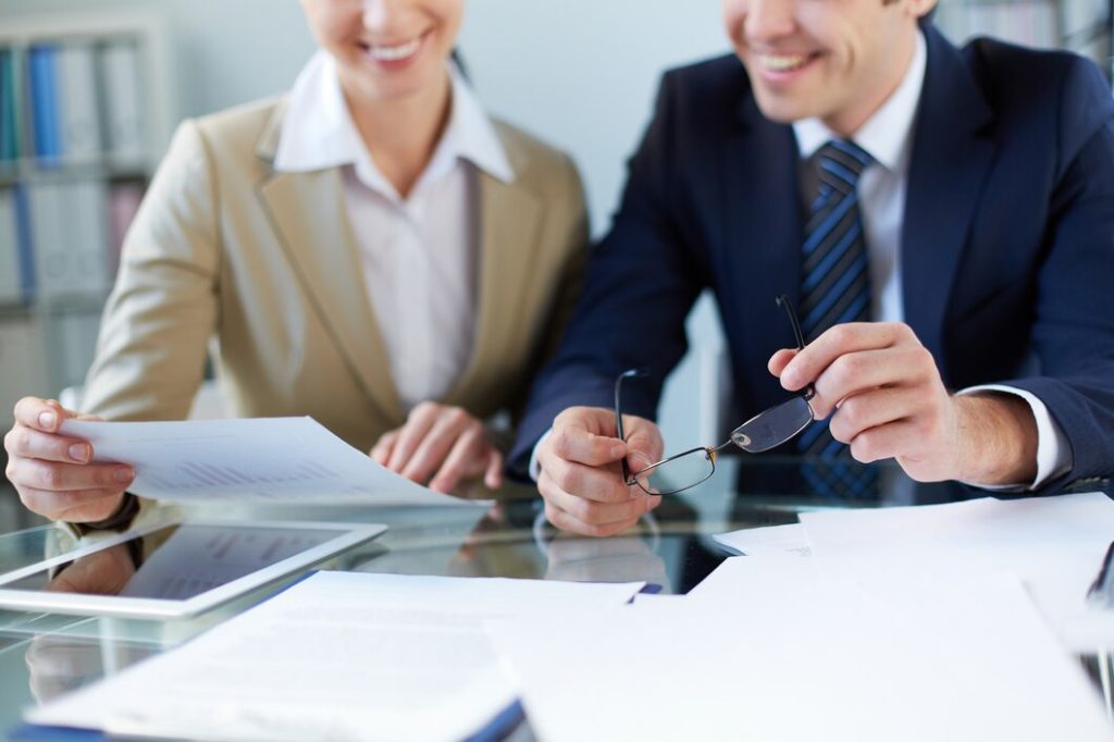 A business lawyer and woman in professional attire reviewing documents at a table in Venice.