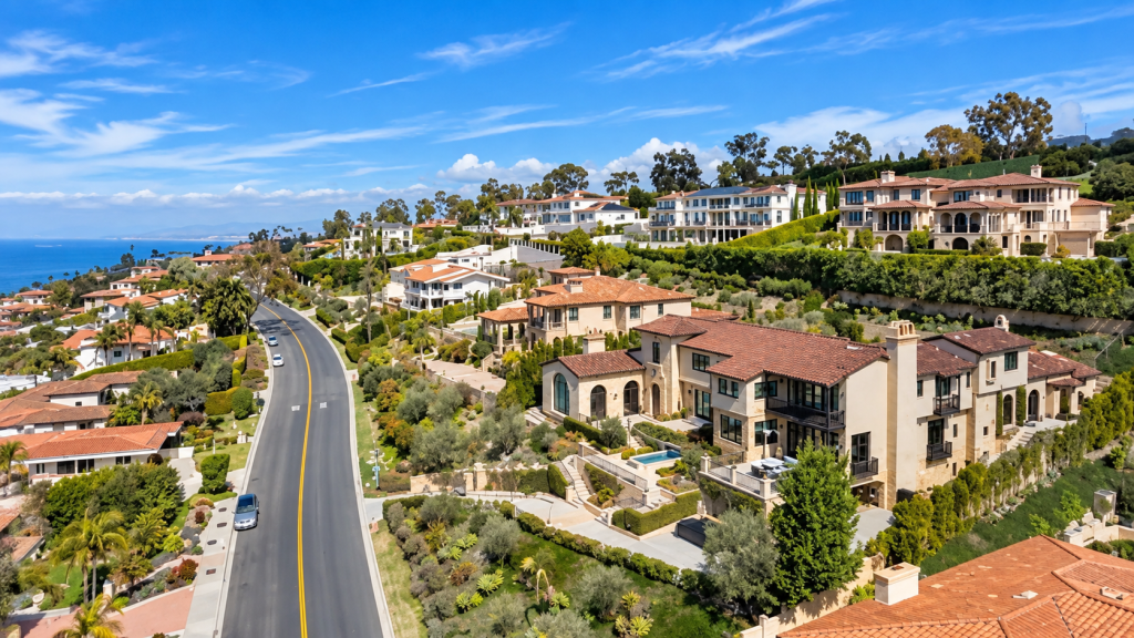 Aerial view of a coastal neighborhood with Mediterranean-style houses and a business lawyer’s office along a winding road overlooking the ocean in Palos Verdes.