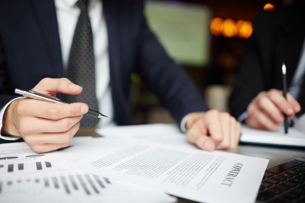 Hands signing a contract