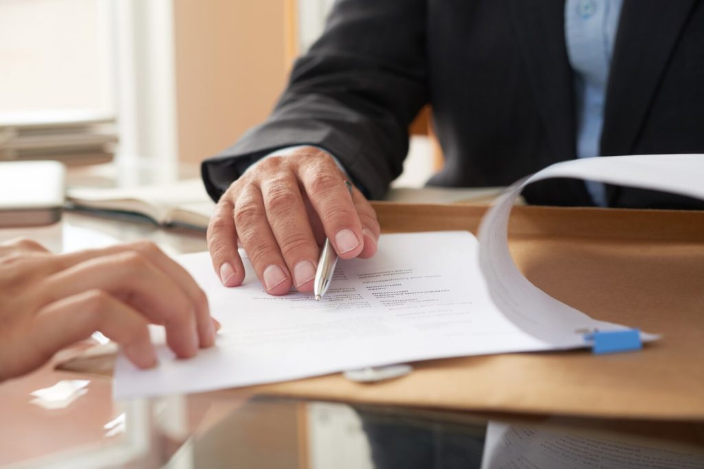 Hands signing a document