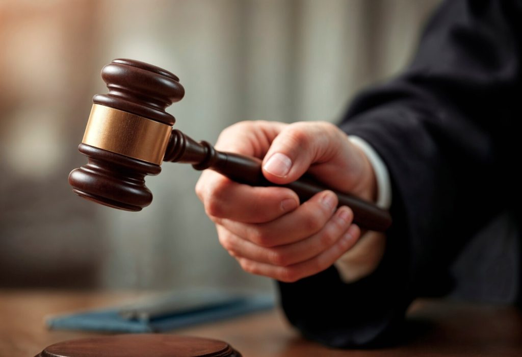 A business lawyer in Gardena wearing a dark robe holds a wooden gavel.