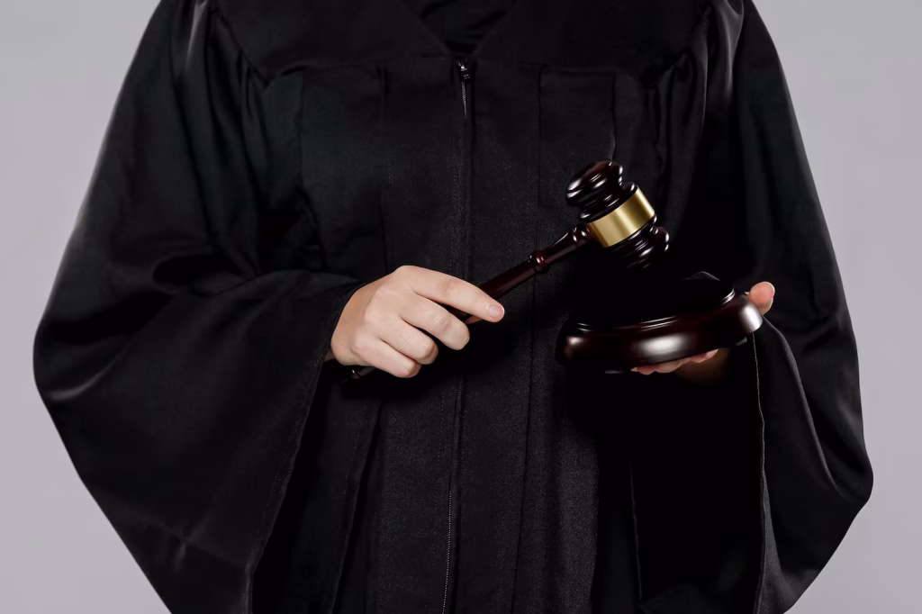 A business lawyer in Glendora wearing a black judicial robe and holding a wooden gavel.