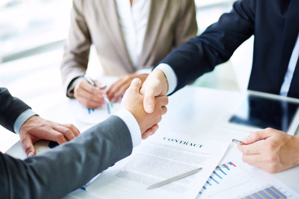 Close-up of a handshake at a meeting table