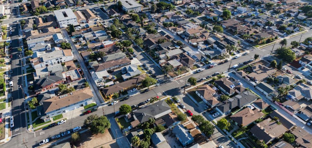 Aerial view of a dense residential neighborhood with single-story homes, intersecting streets, and parked cars near a business lawyer in Gardena.