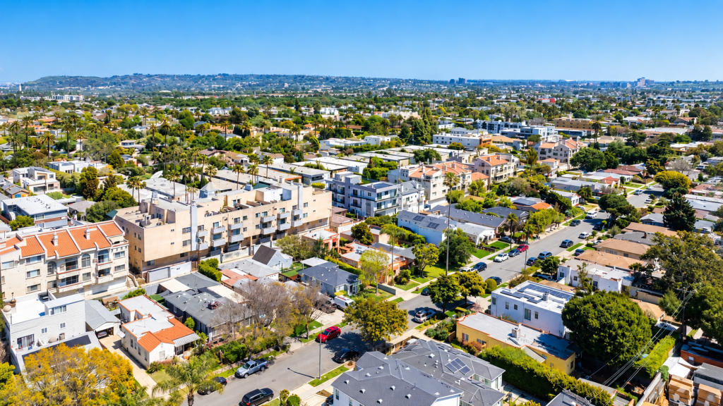 Aerial view of the Mar Vista neighborhood with apartment buildings, houses, and tree-lined streets under a clear blue sky.