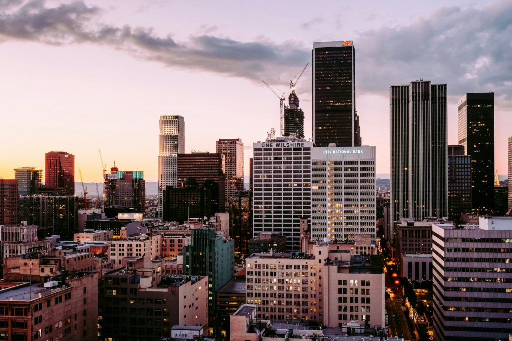 The Los Angeles skyline at sunset featuring the One Wilshire and City National Bank buildings, a backdrop for a corporate law attorney in Los Angeles.