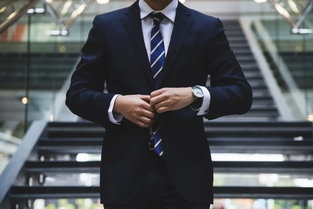 Man in a suit with hands clasped