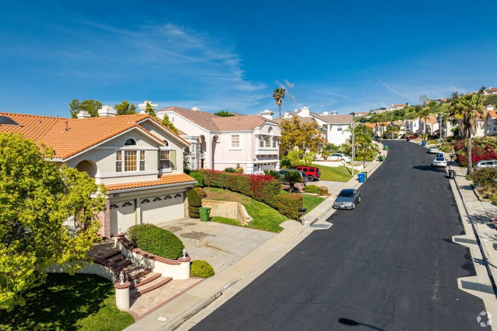 Aerial view of a sunny residential suburban street near a business lawyer in Porter Ranch, showing houses and parked cars.