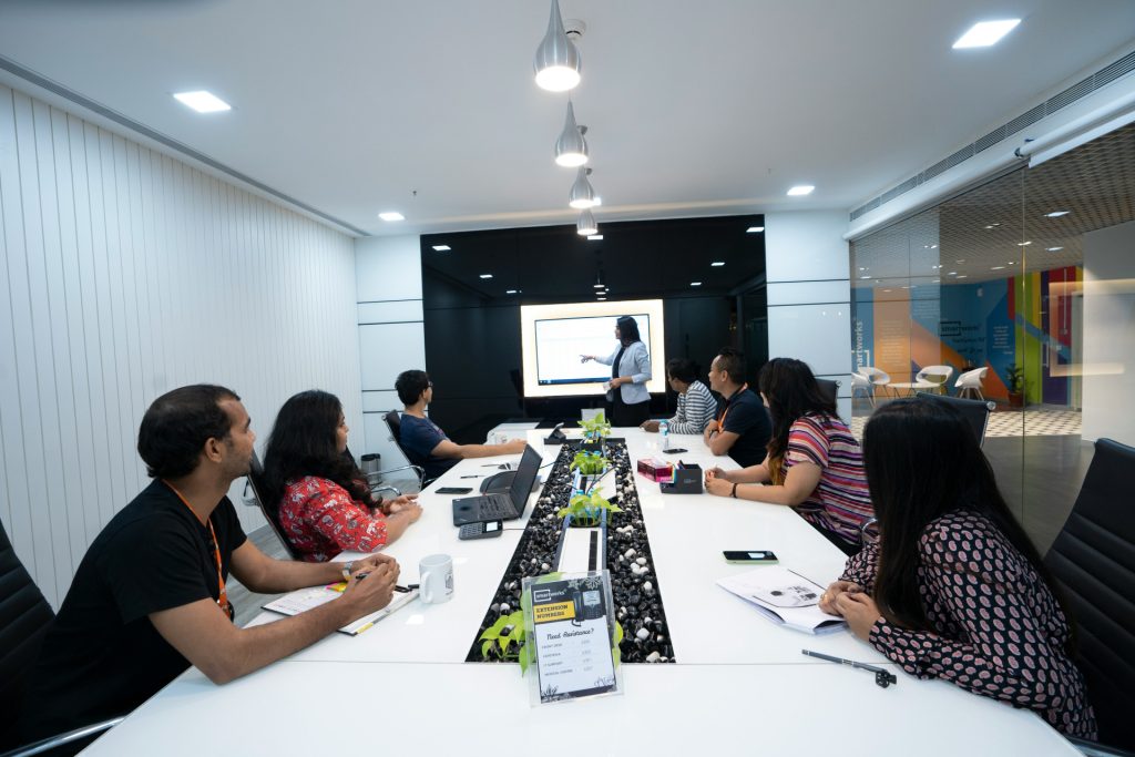 A commercial law attorney in Los Angeles gives a presentation to a group of colleagues seated around a long conference table.