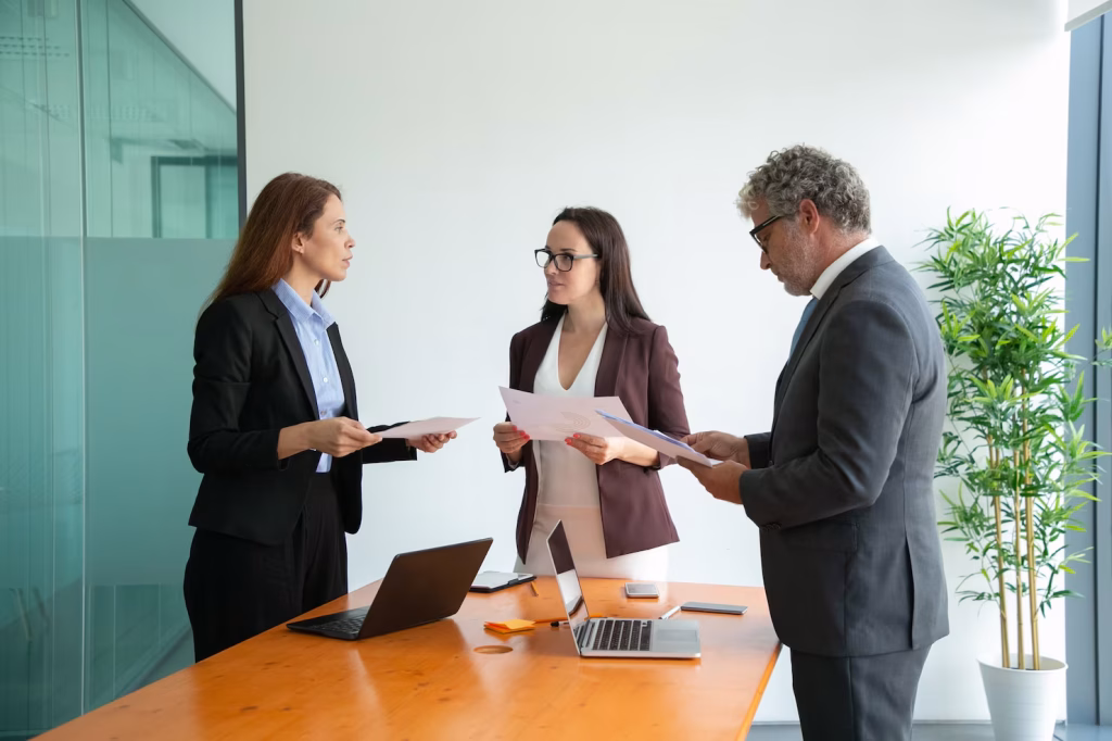 Two colleagues talking while holding papers