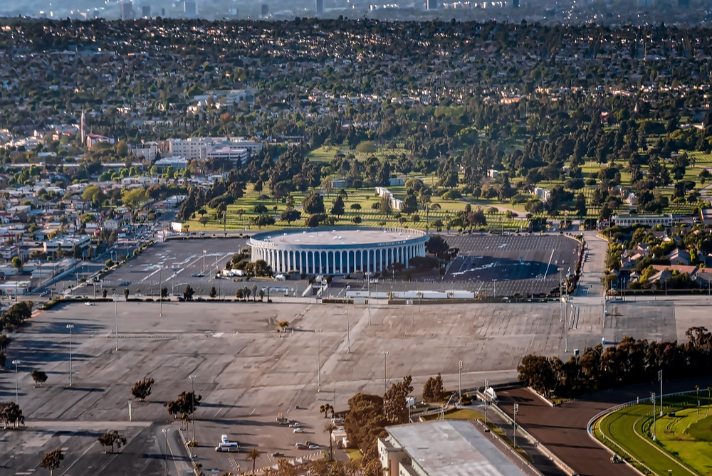 Aerial view of the Forum arena in Inglewood, California, near the offices of a business lawyer in Inglewood, surrounded by a large parking lot and urban landscape.