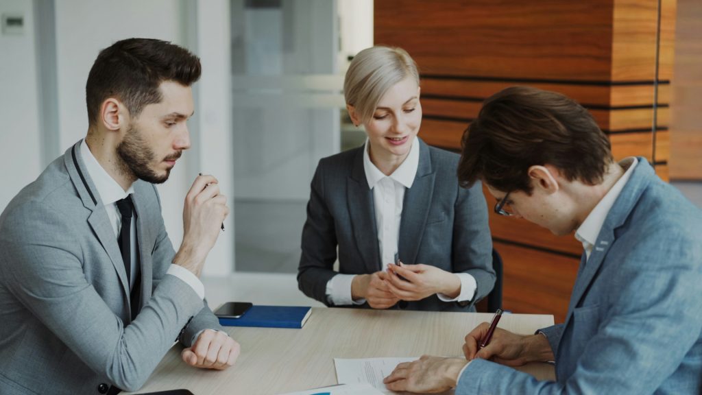 Three colleagues meeting around a laptop